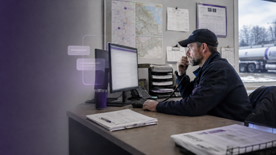 A dispatcher on the phone at the desk while KozyOps surfaces information on screen